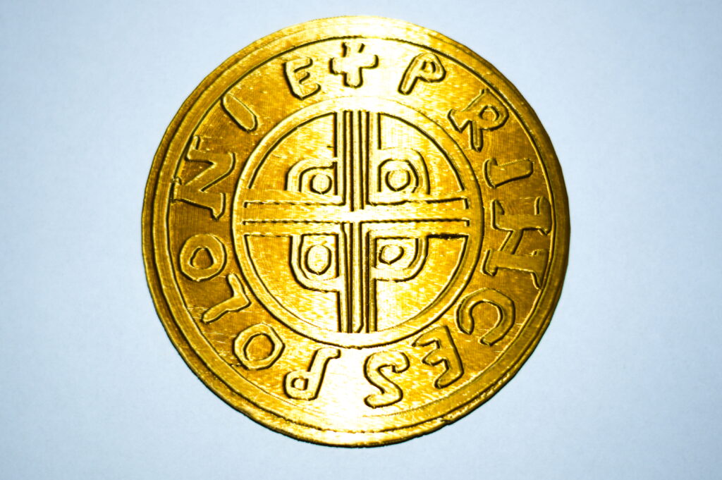 Moneta Princes Polonie, złote PLA domieszkowane mosiądzem, rewers Rewers monety Princes Polonie: okrągłą monetę okala napis "Princes Polonie" rozdzielany krzyżykiem. Wewnątrz koło, w którym znajduje się ozdobny krzyż.