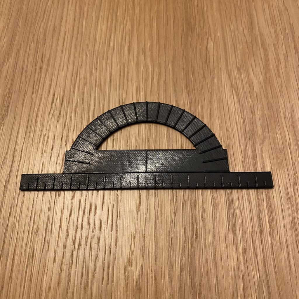 kątomierz kreślarski, PLA srebrne Srebrny kątomierz kreślarski z dołączoną, stałą linijką o przedziałce co pół centymetra.