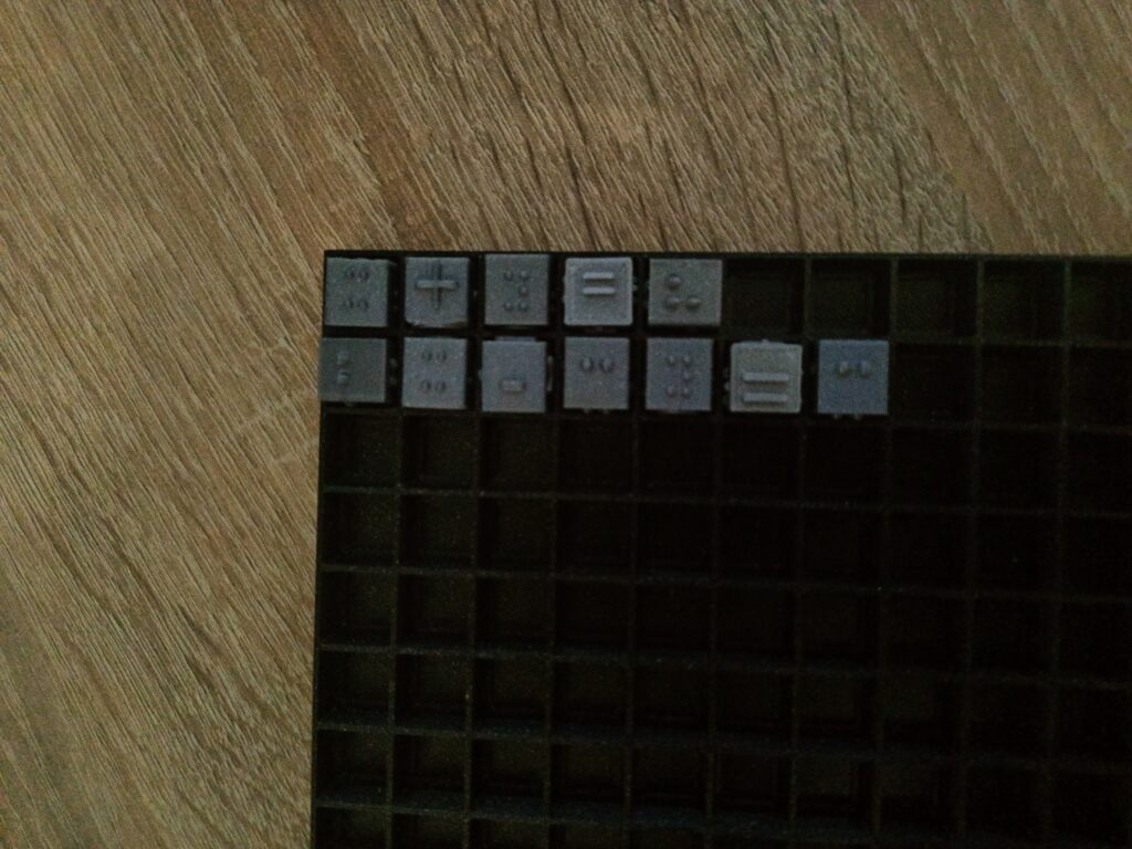 Kubarytmy, kostki Na planszy kubarytmów ułożone równanie wykorzystujące cyfry, zmienne i operatory matematyczne