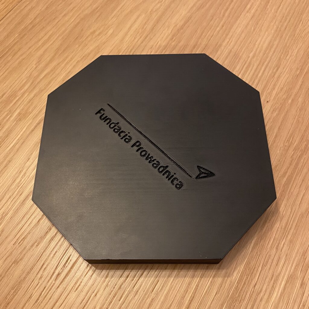 Chińczyk, zamknięta plansza Chińczyk: zamknięta plansza ma kształt ośmiokątnego pudełka z wyciętym logo Fundacji Prowadnica.