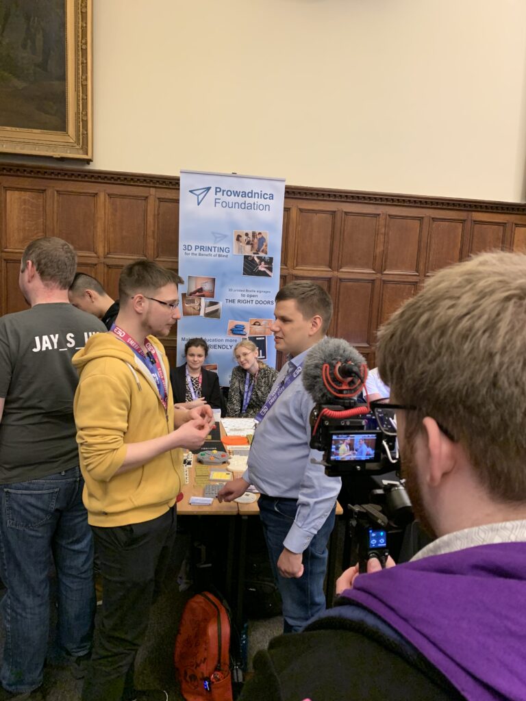 Dawid rozmawia z prezenterem telewizyjnym przy stanowisku fundacji