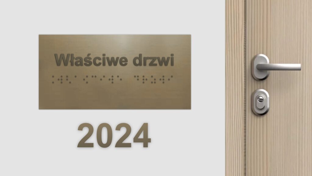 Na ścianie wisi tabliczka z napisem w czarnodruku i brajlu „właściwe drzwi.” Po prawej od tabliczki drewniane drzwi z metalową klamką. Pod tabliczką tekst „2024.”